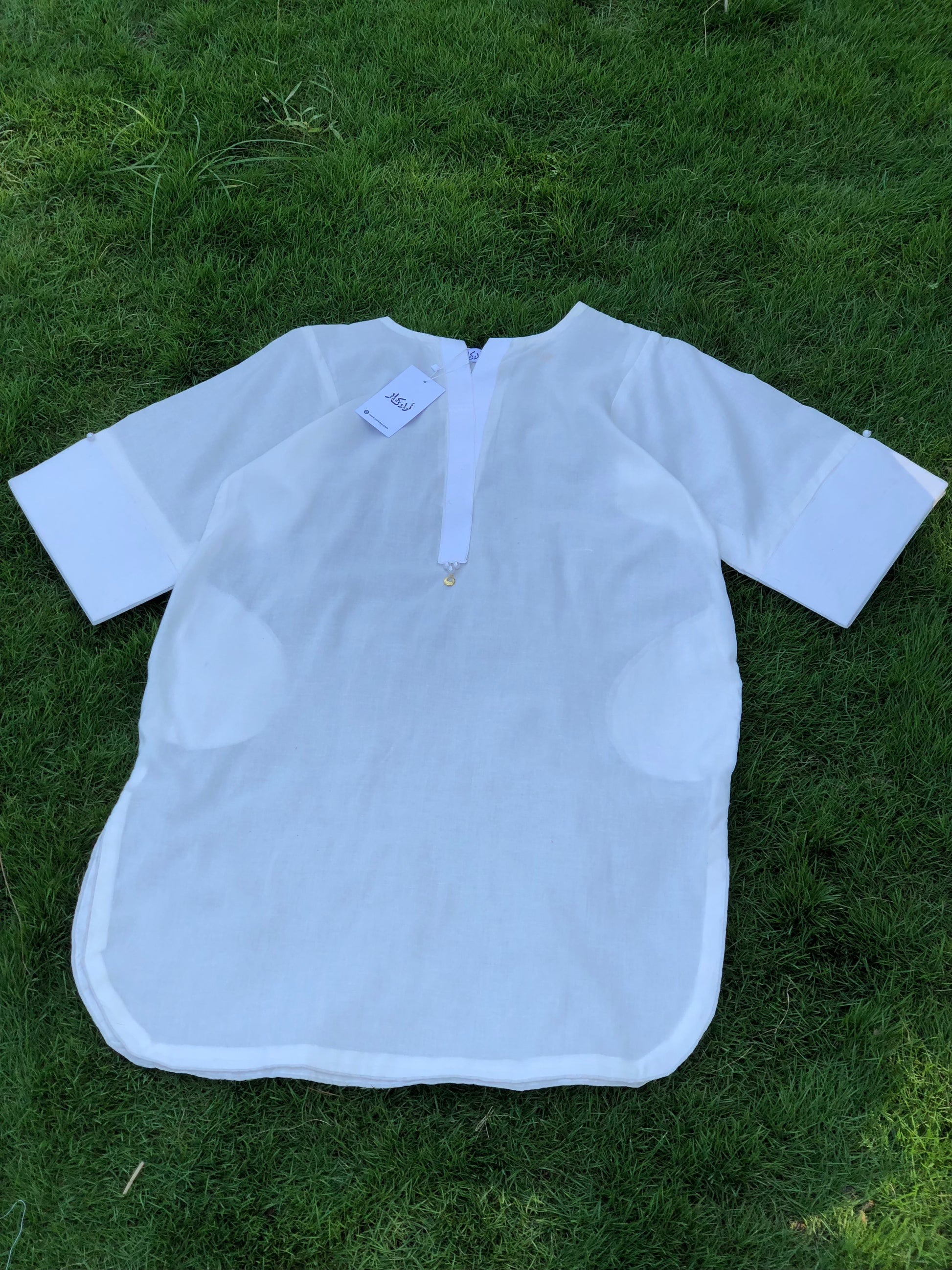 White shirt with a tag on grass