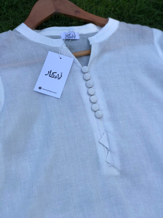 White shirt with buttons on a hanger against a grassy background